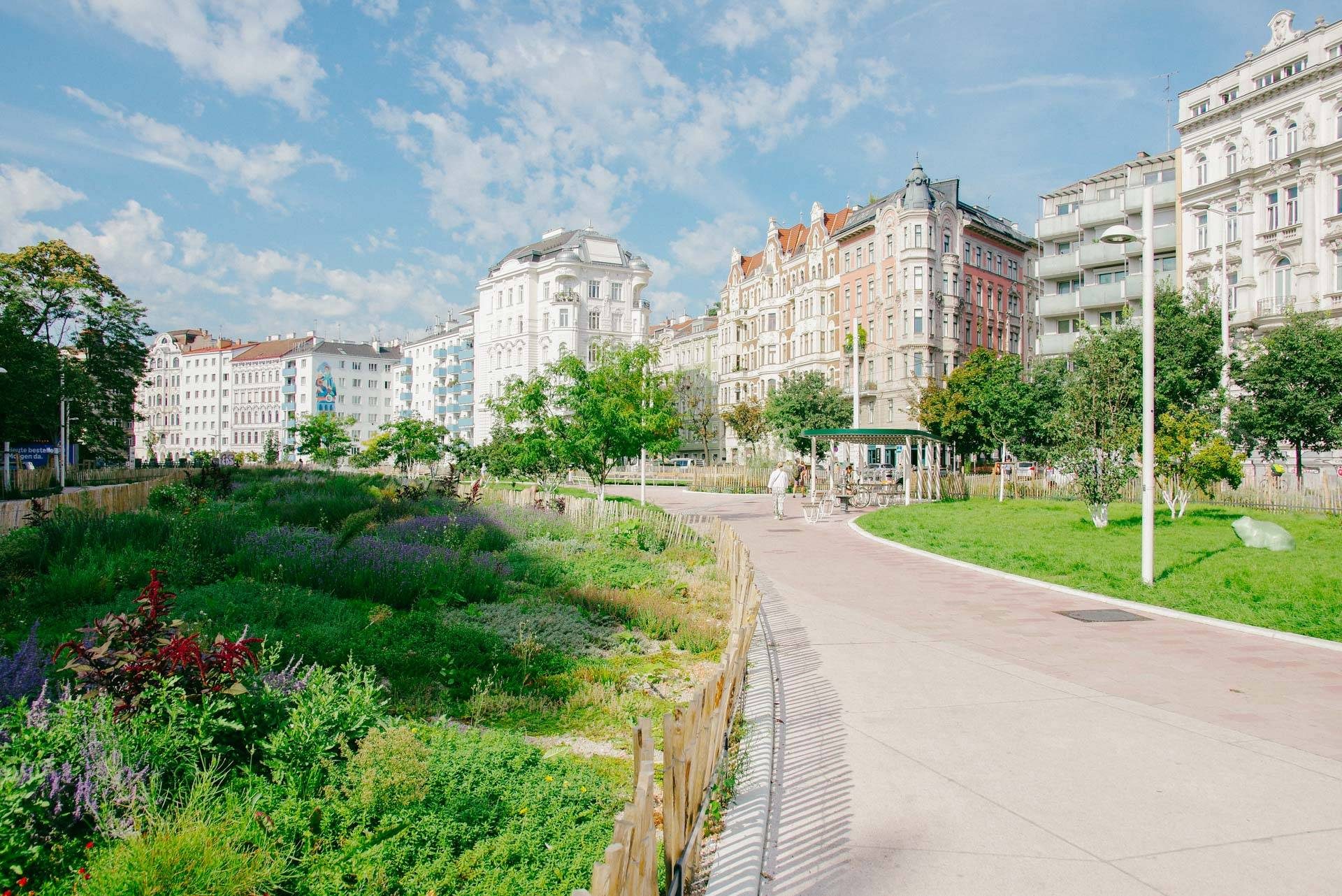 Naschpark mit Staudenbeeten, dahinter die Gründerzeithäuser der Linken Wienzeile